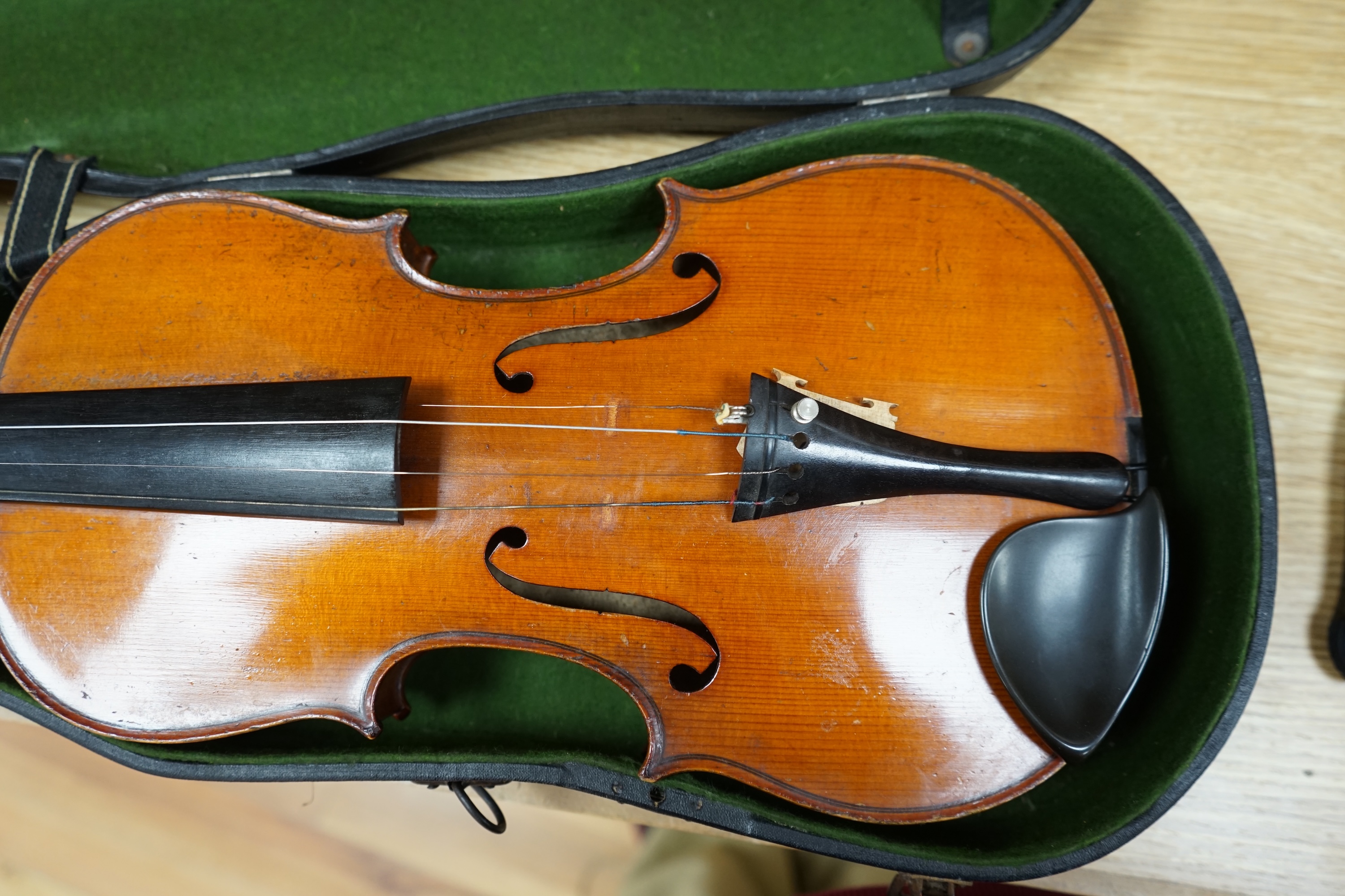 A cased early 20th century violin with bow, no label, back measures 35.5cm. Condition - fair to good